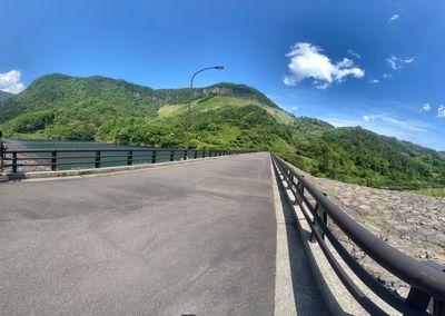 Road by bridge against sky