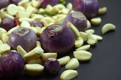 A mixture of cooking ingredients.peeled garlic,onions and chili peppers on a black background