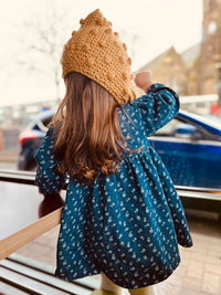 Rear view of woman wearing hat standing outdoors