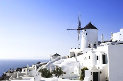 Traditional windmills at santorini against clear sky