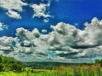 Scenic view of field against cloudy sky