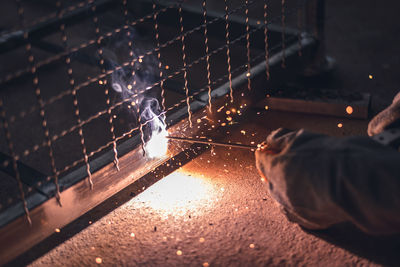 Close-up of person hand on illuminated metal at night