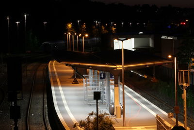 Illuminated street lights by buildings at night