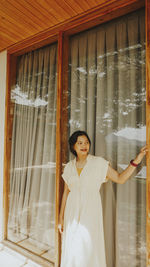 Woman standing by window