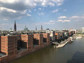 View of buildings in city against cloudy sky