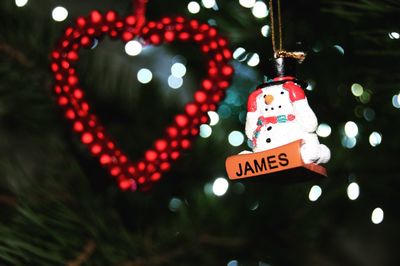 Close-up of illuminated heart shape hanging on christmas tree