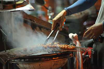 Person preparing food at market stall