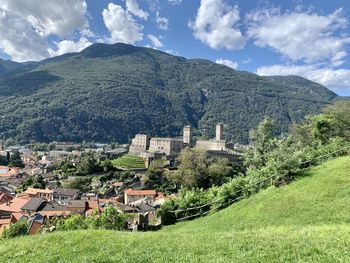 Aerial view of townscape by mountain against sky