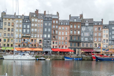 Boats moored on canal against buildings in city