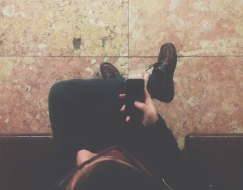 Low section of man photographing with mobile phone