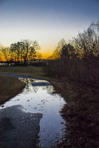 Scenic view of river against clear sky during sunset