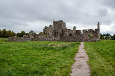 Old ruins on field against sky