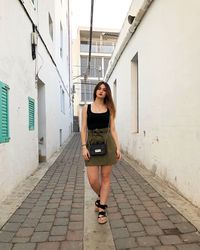 Portrait of woman standing amidst buildings