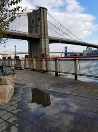 Bridge over river in city against sky