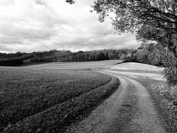 Road amidst field against sky