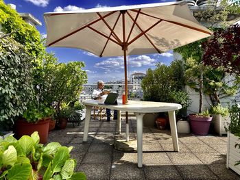 Empty chairs and table by plants