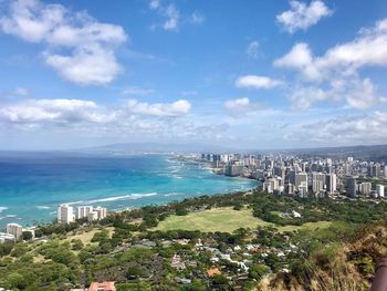 High angle view of city by sea against sky