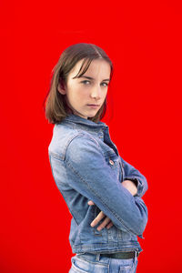 Portrait of a teenage girl against red background