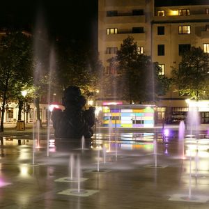 Blurred motion of woman walking on city street at night