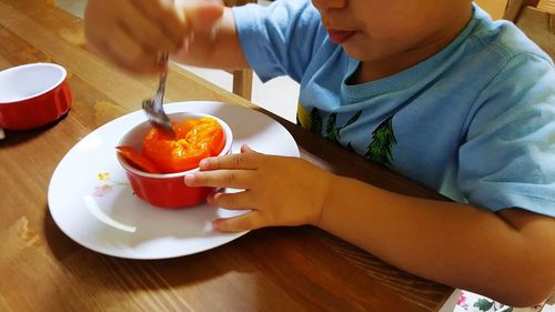 Close-up of boy sitting on table