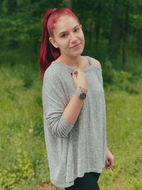 Portrait of smiling young woman standing on field