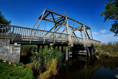 Low angle view of bridge over river against sky