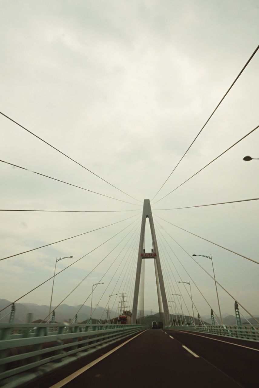 transportation, connection, the way forward, diminishing perspective, sky, vanishing point, cable, bridge - man made structure, power line, railroad track, road, engineering, electricity pylon, long, cloud - sky, suspension bridge, road marking, rail transportation, built structure, travel