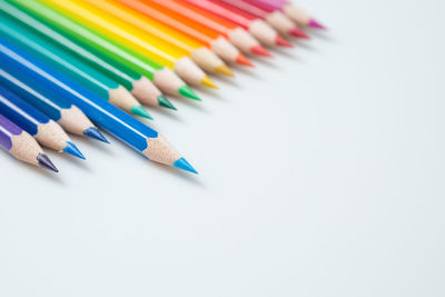 High angle view of colored pencils against white background