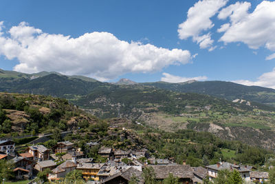 Scenic view of town by mountains against sky