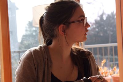 Close-up of woman looking through window