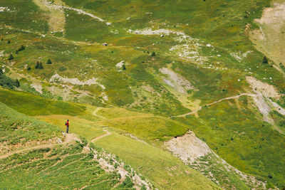 High angle view of road amidst green landscape. a man in the mountain. a tourist in the alps
