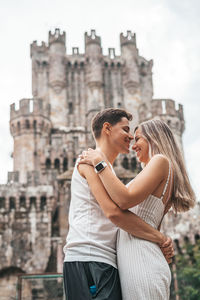 Young couple standing against built structure