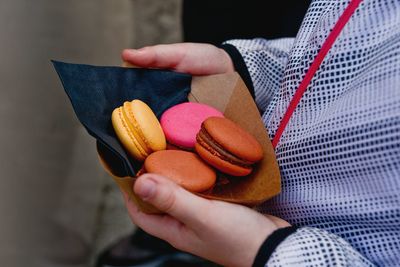 Cropped image of person holding macaroons