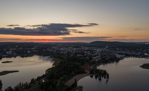 High angle view of river and buildings against sky during sunset