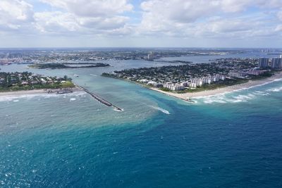 Aerial view of city by lake worth inlet against sky