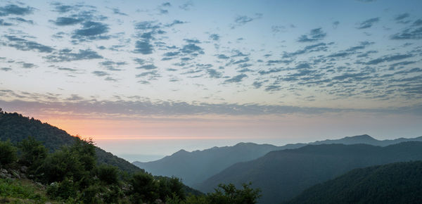 Scenic view of silhouette mountains against sky at sunset