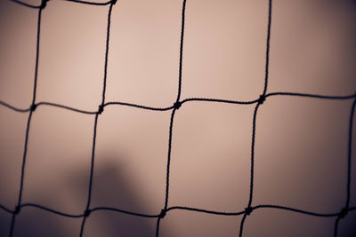 Close-up of barbed wire fence against sky