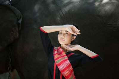 Mid adult woman looking away while standing in hat