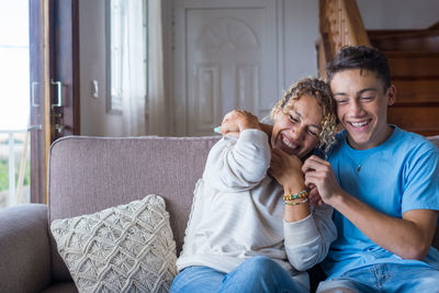 Happy friends sitting on sofa