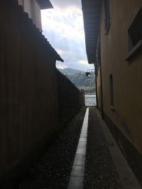 Road amidst buildings against sky