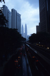 Vehicles on road in city against sky