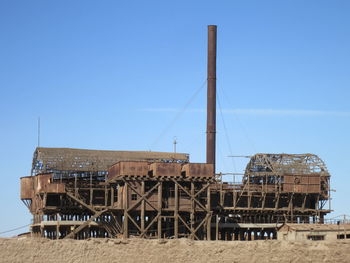 Low angle view of abandoned factory against blue sky