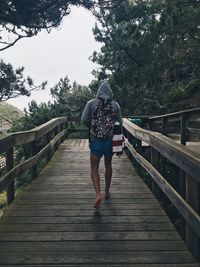 Rear view of woman walking on footbridge