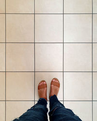 Low section of woman standing on tiled floor