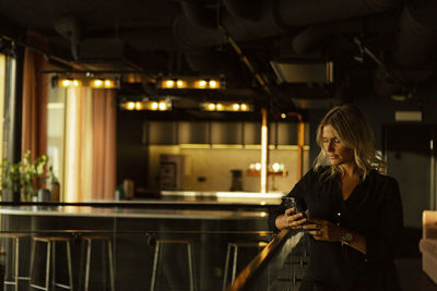 Woman using phone in cafe
