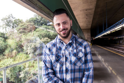 Portrait of a smiling young man on railroad track