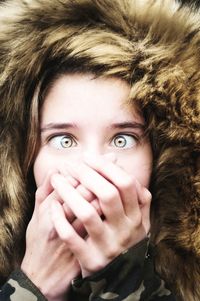 Close-up portrait of young woman covering face