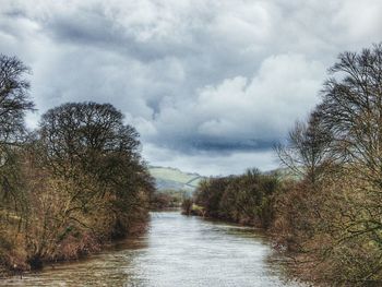 Scenic view of river against cloudy sky