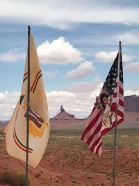 Flag on landscape against sky