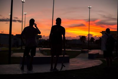 Silhouette people walking at park during sunset